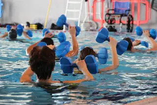 A couple of women float in an indoor pool holding float weights. Text overlay: Deep Water Running (Ages: 13+)