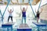 Several people are on floating yoga mats in a pool. Text overlay: Float Yoga