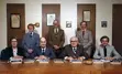 three councillors standing and four sitting around a table